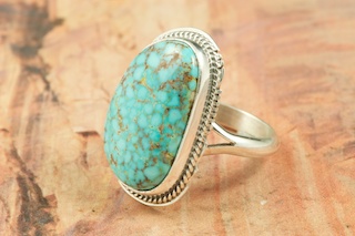 Genuine High Grade Kingman Web Turquoise set in Sterling Silver Ring. Created by Navajo Artist Larson Lee. Signed by the artist. The Mineral Park Mine, in the Cerbat Mountains 14 miles northwest of Kingman, was first mined by Indians centuries before white man came to the area. It is one of the three sites of prehistoric mining localities in the state of Arizona. Mineral Park was the most extensively worked area by the Indians of the three. S.A. �Chuck� Colbaugh found a cache of stone hammers uncovered in ancient trenches and tunnels, when he had the turquoise mining concession in May of 1962. Ithaca Peak and Turquoise Mine (formally called Aztec Mountain or Aztec Peak) are the most famous of the peaks in the area containing turquoise.